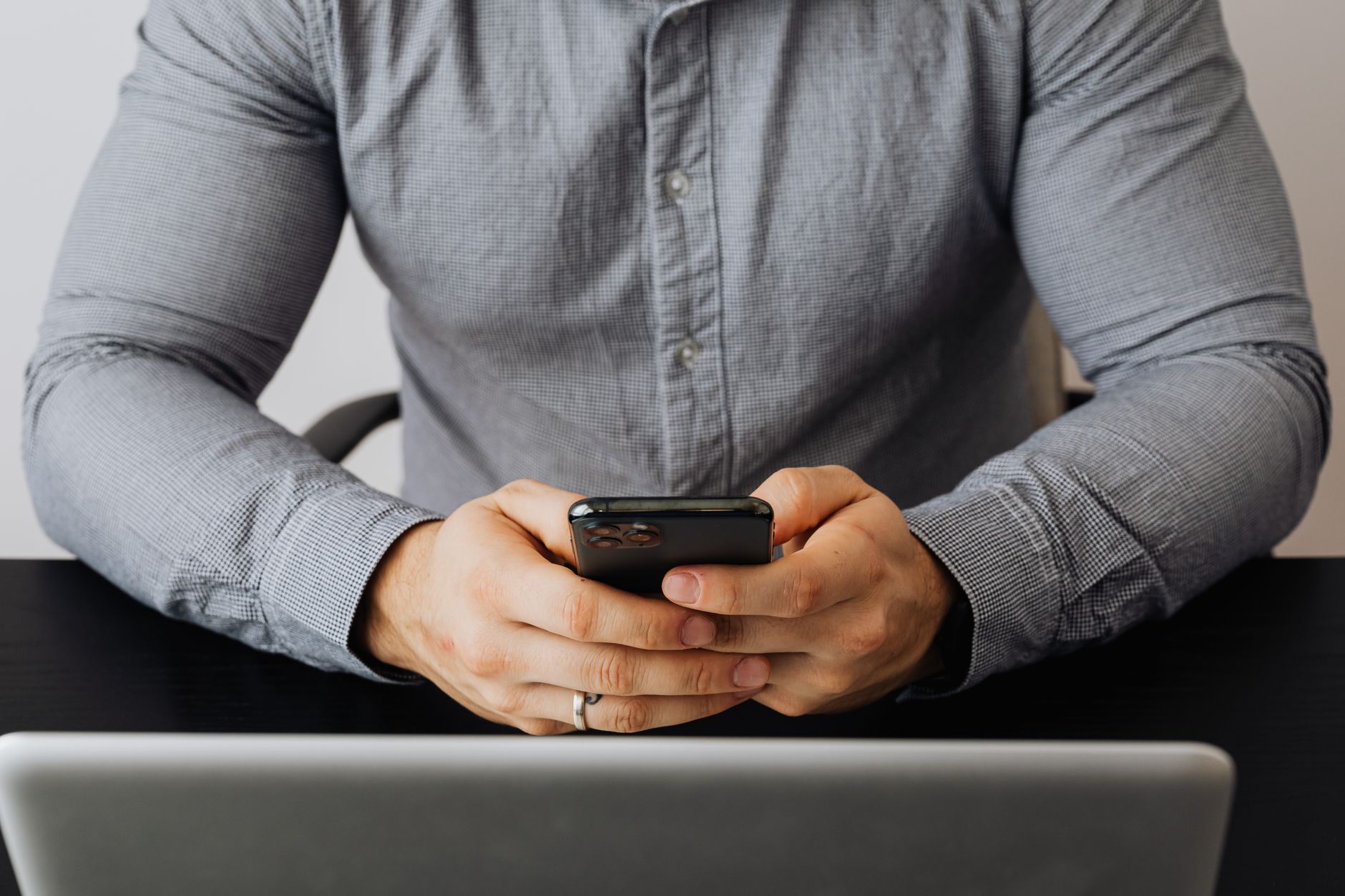 An employee using a self-service app on a smartphone at a desk