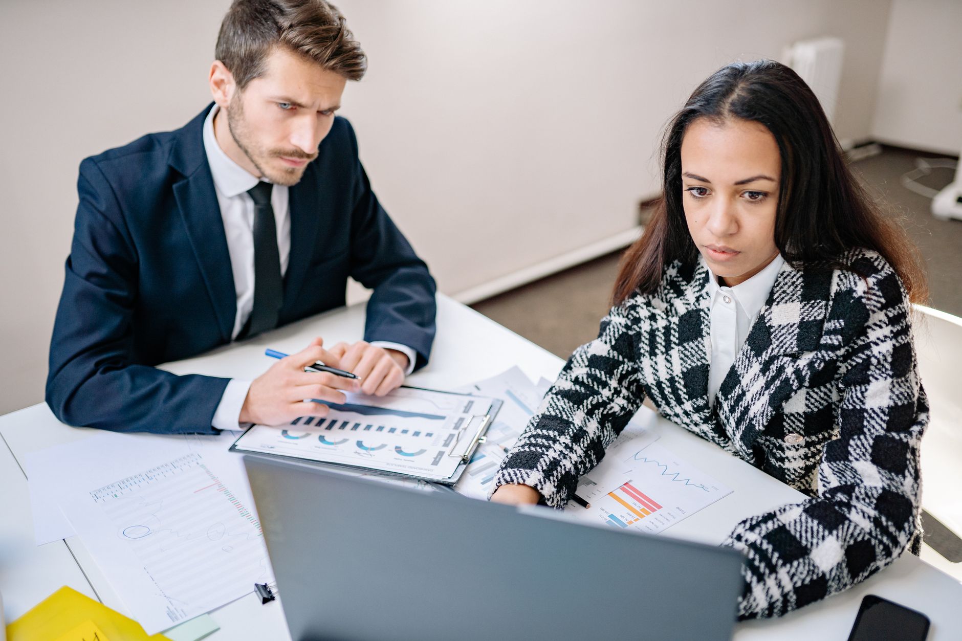 Two colleagues reviewing financial charts together at a desk