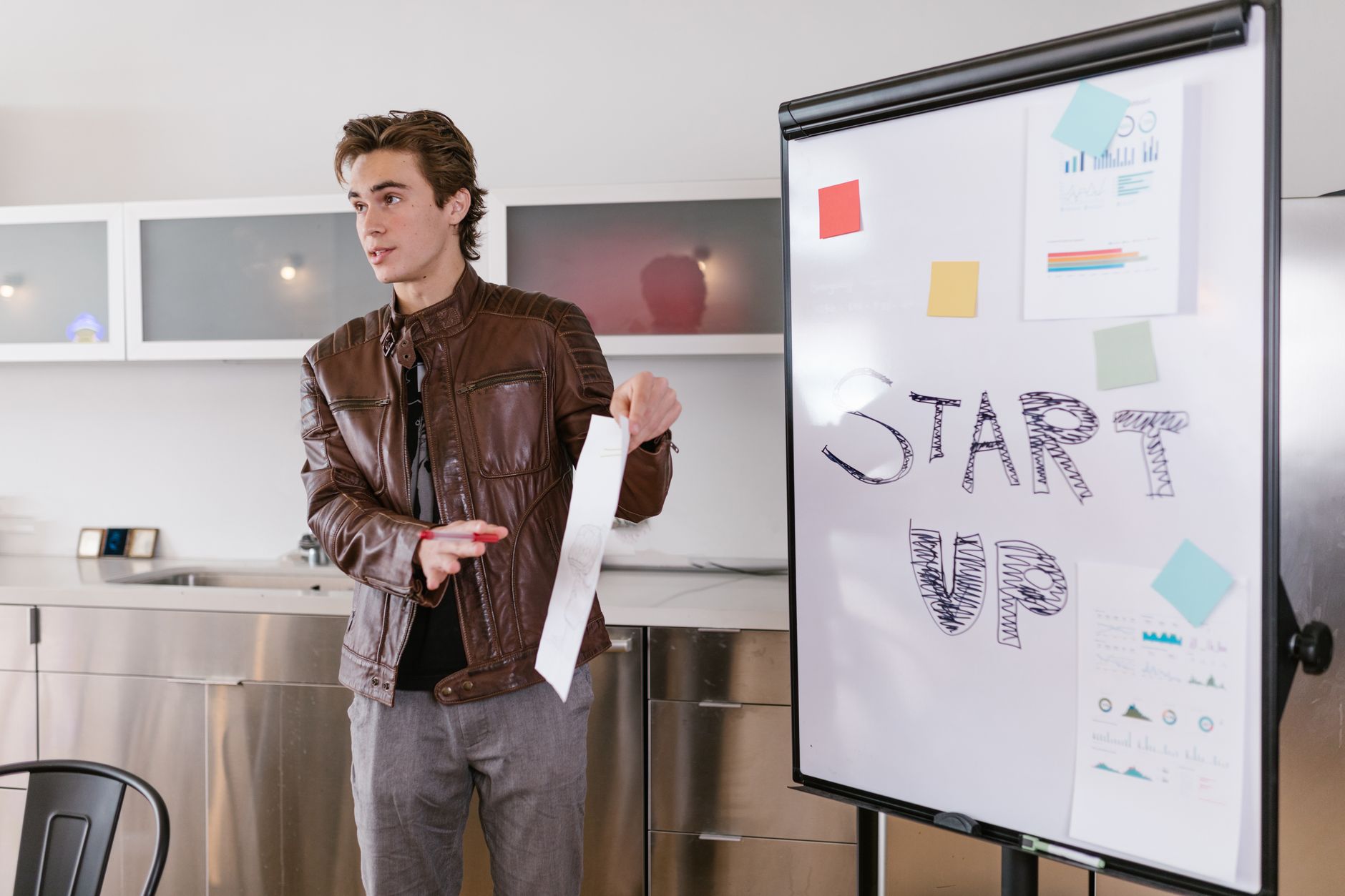 A founder presenting startup plans at a flip chart in an office