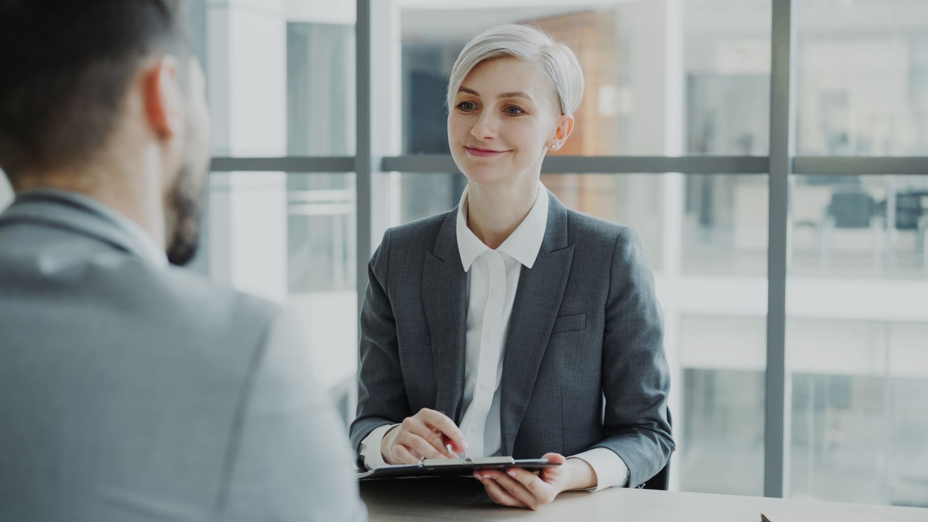 An HR manager interviewing a candidate in a modern office